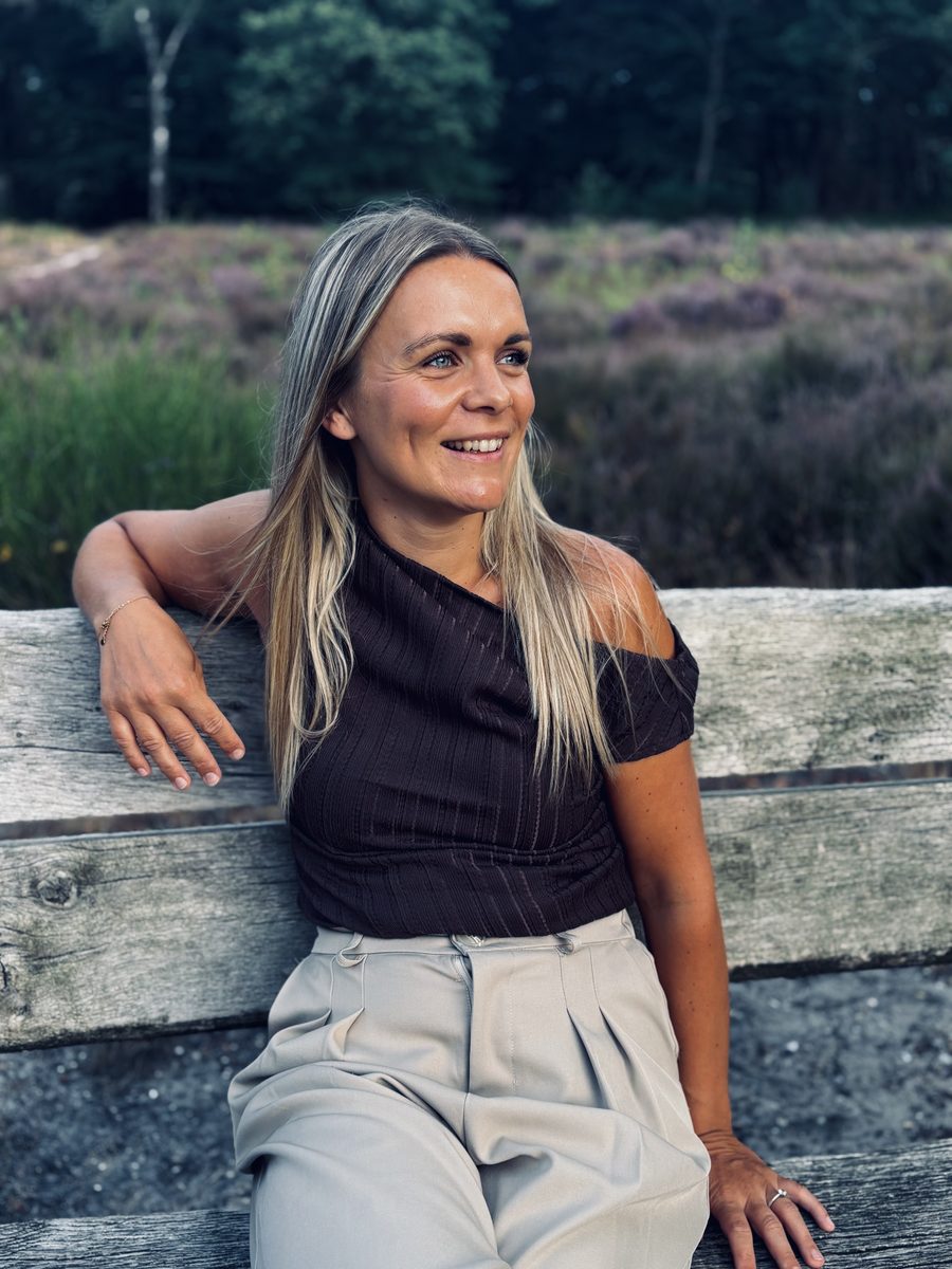 Bri zittend op een bankje op de heide